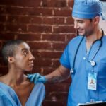 A medical professional consults a patient with a supportive and positive demeanor in a clinic setting.